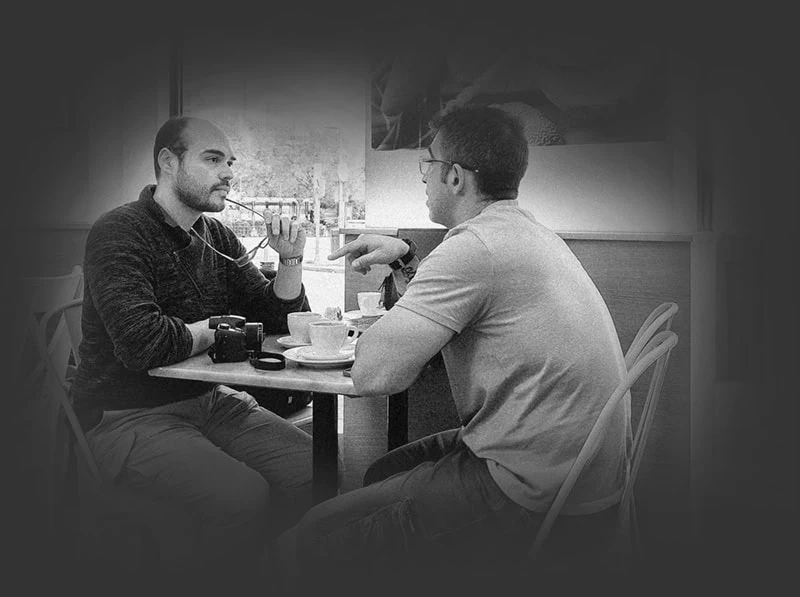 Miguel Santacruz reunido con el encargado de una cafetería, dialogando sobre su desarrollo de página web.